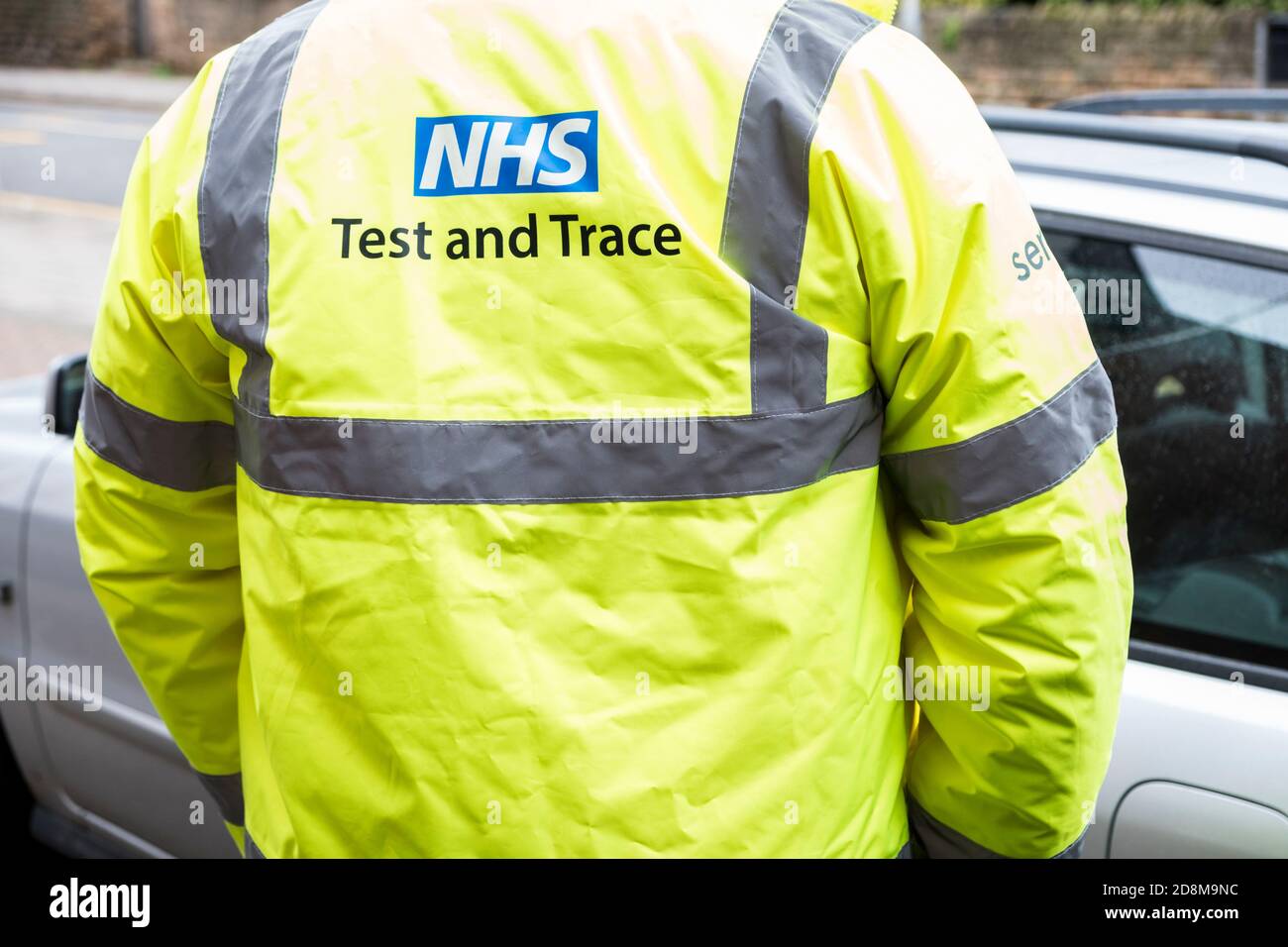 Persona con NHS Test y Trace hi Vis Jacket involucrada en pruebas y rastreo de coronavirus Covid-19, Inglaterra, Reino Unido Foto de stock