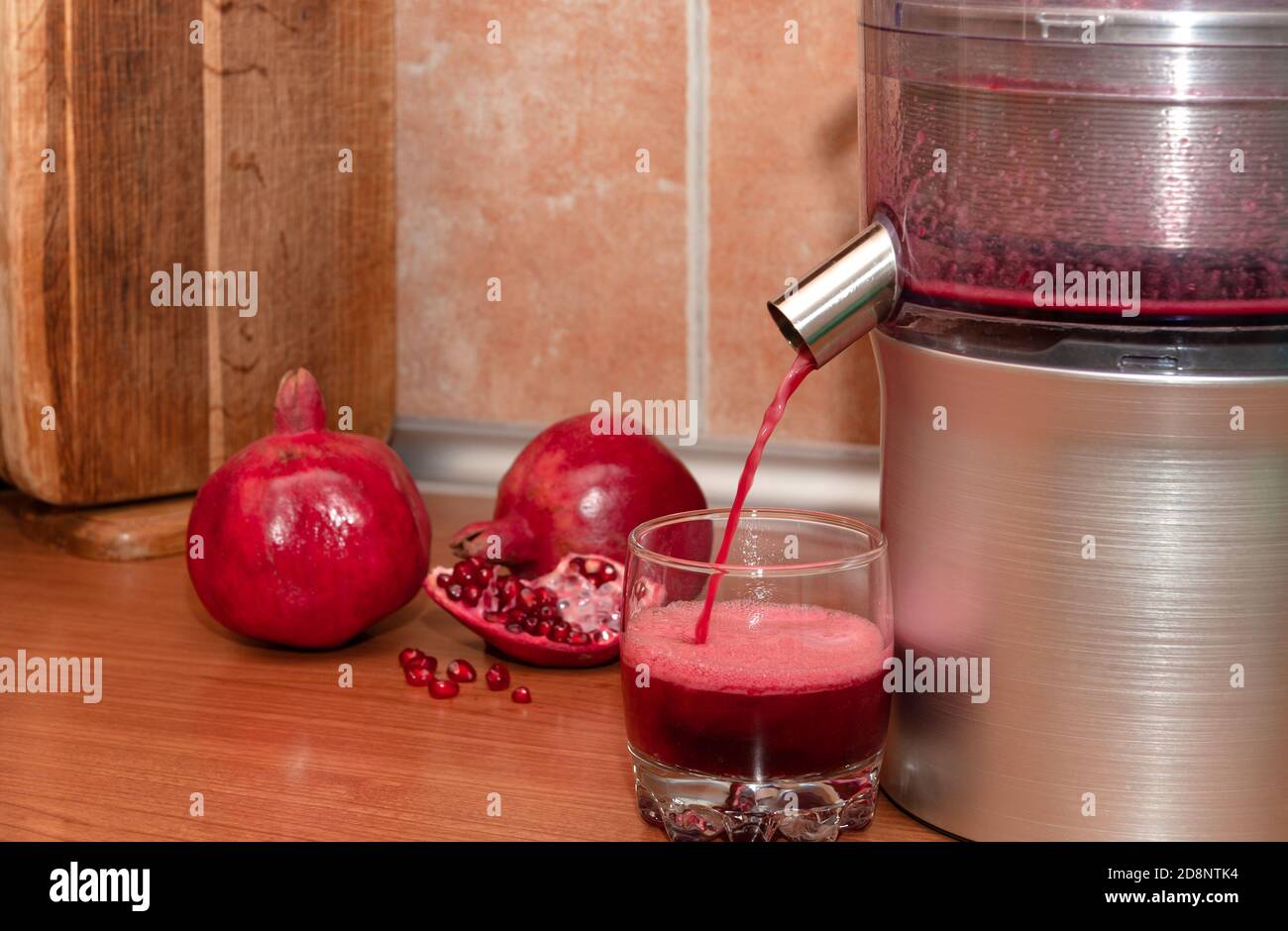 El zumo de Granada se vierte de una licuadora en un vaso. Hacer jugo en  casa Fotografía de stock - Alamy