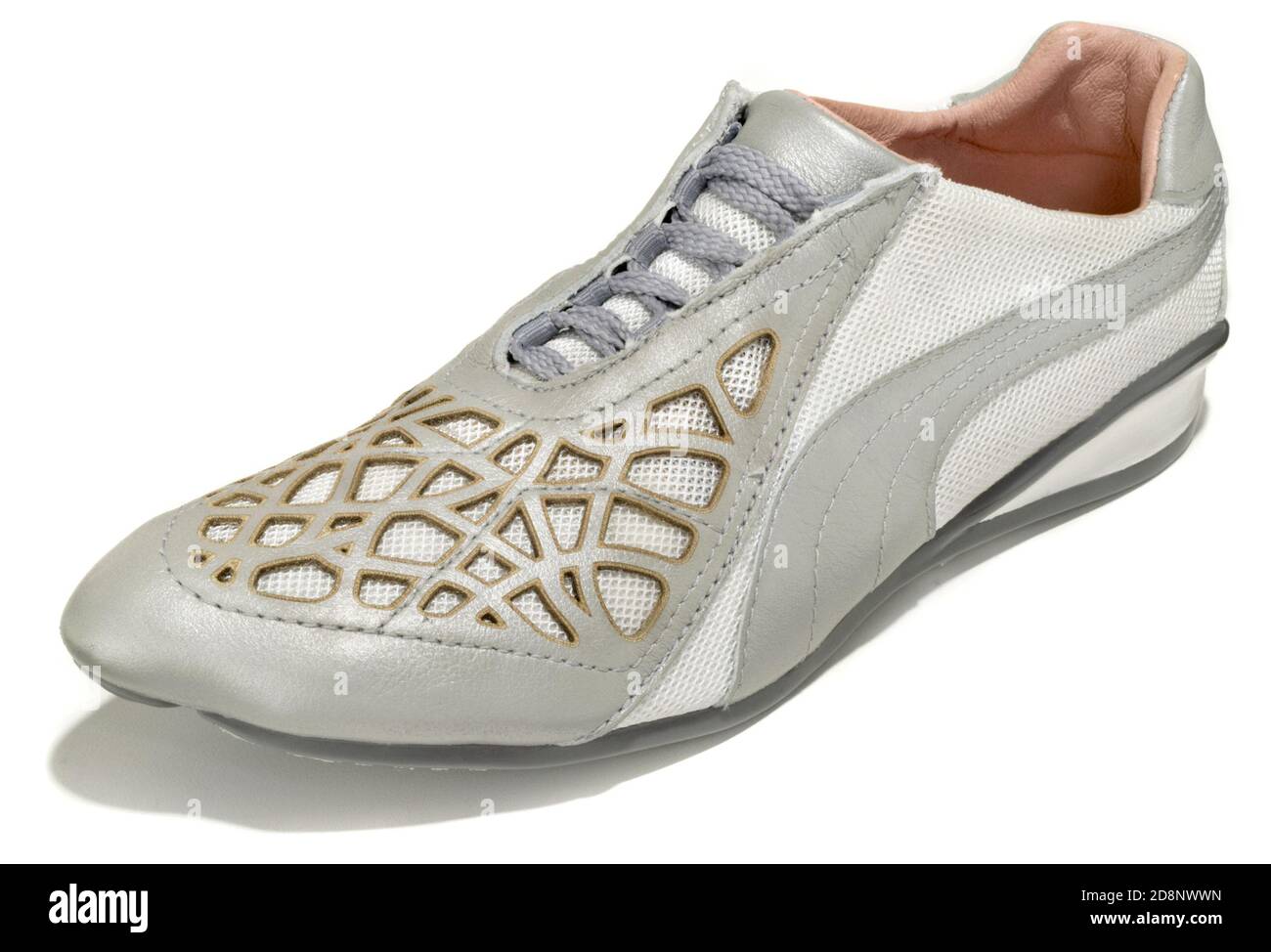 Unas zapatillas de running blancas y plateadas con detalles de color dorado Diseñado por Puma en colaboración con Alexander McQueen fotografiado en un fondo blanco Fotografía de stock Alamy