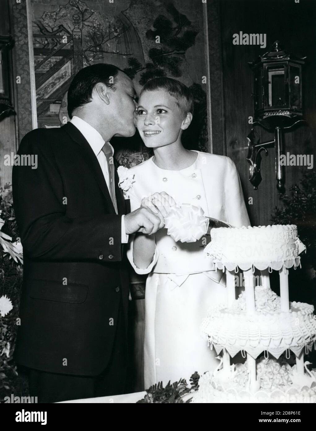 Julio 19, 1966 - las Vegas, Nevada - FRANK SINATRA, 50, izquierda, da a su nueva novia, MIA FARROW, 21, un beso mientras cortan la torta en su boda. (Imagen de crédito: © Keystone Press Agency/Keystone USA via ZUMAPRESS.com) Foto de stock