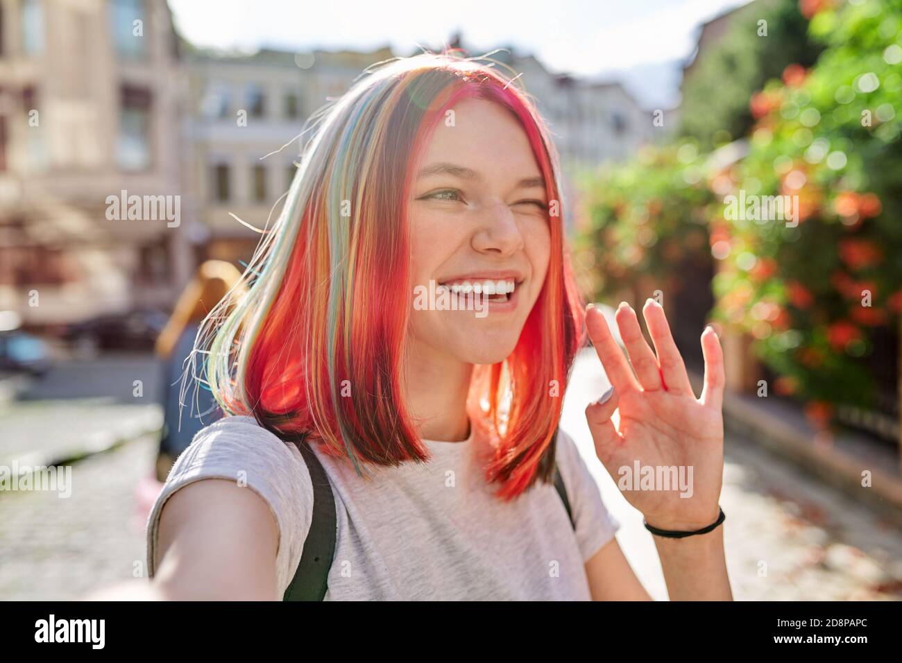 Una adolescente de moda mira la webcam y habla en la ciudad calle Foto de stock