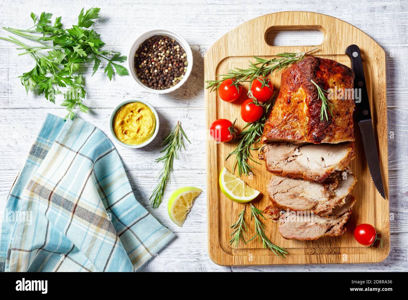 Lomo de cerdo asado en rodajas: Un trozo de carne de cerdo frotada con  mostaza y especias: romero, laurel, jugo de lima horneado en el horno  servido en un corte Fotografía de