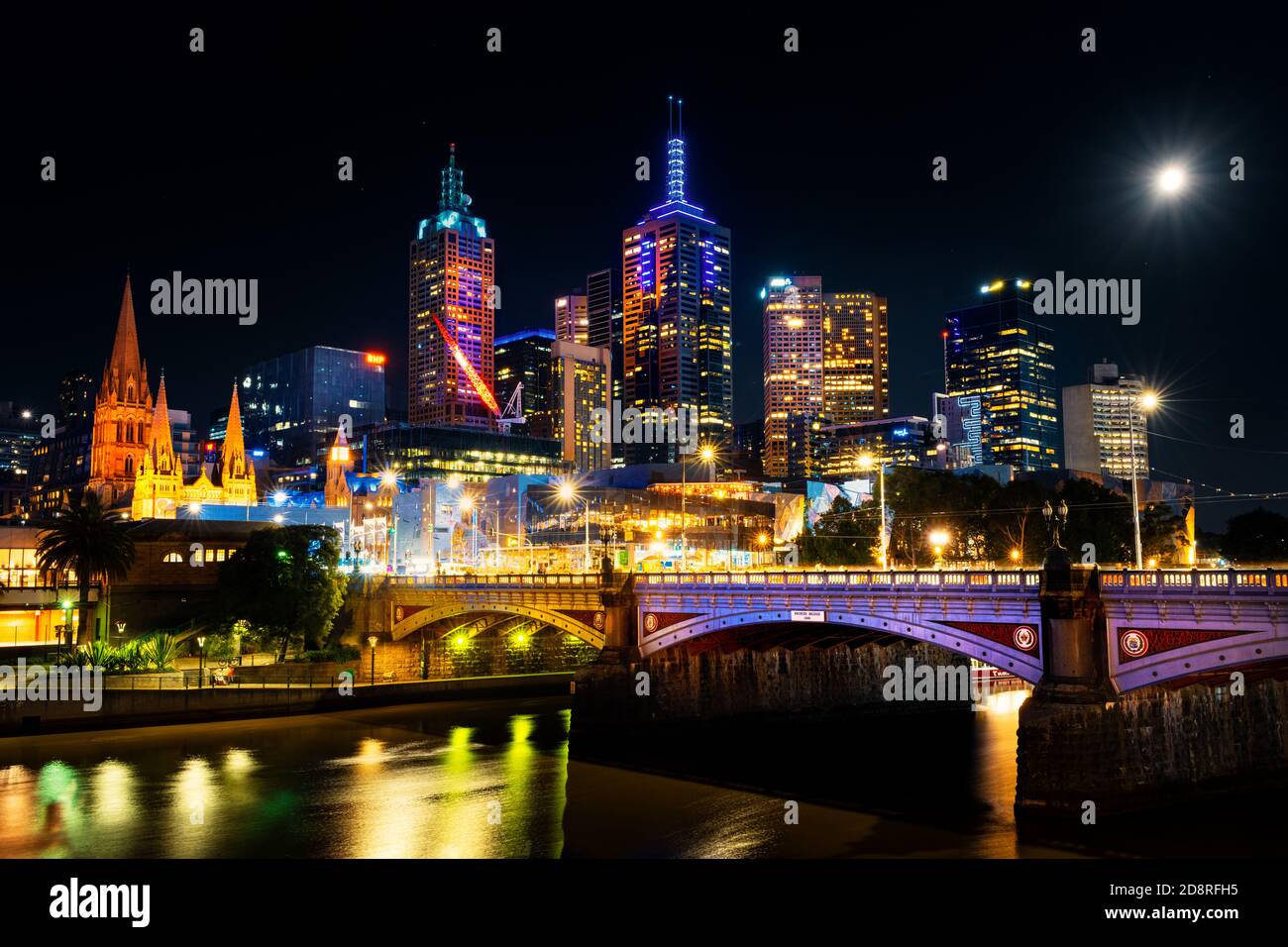 Melbourne llena de color por la noche bajo la luna llena. Foto de stock