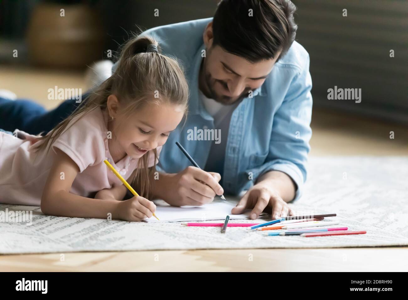Feliz niña pequeña dibujando fotos con papá. Foto de stock