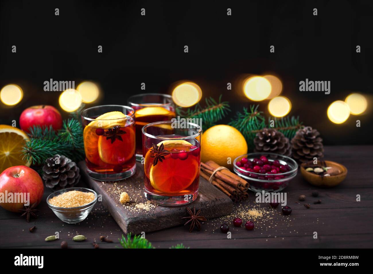 Vino tinto de Navidad con especias y naranjas sobre mesa rústica de madera. Bebida caliente tradicional para las vacaciones de Navidad e invierno. Foto de stock