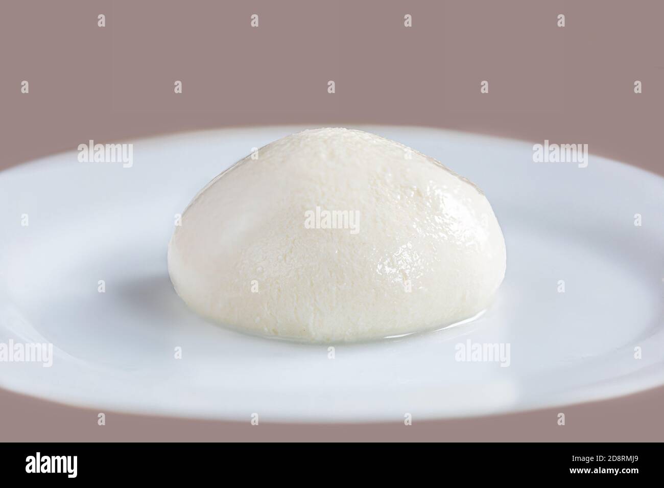 Queso mozzarella Búfalo en un plato blanco de cerca. Mozzarella tradicional italiana Foto de stock