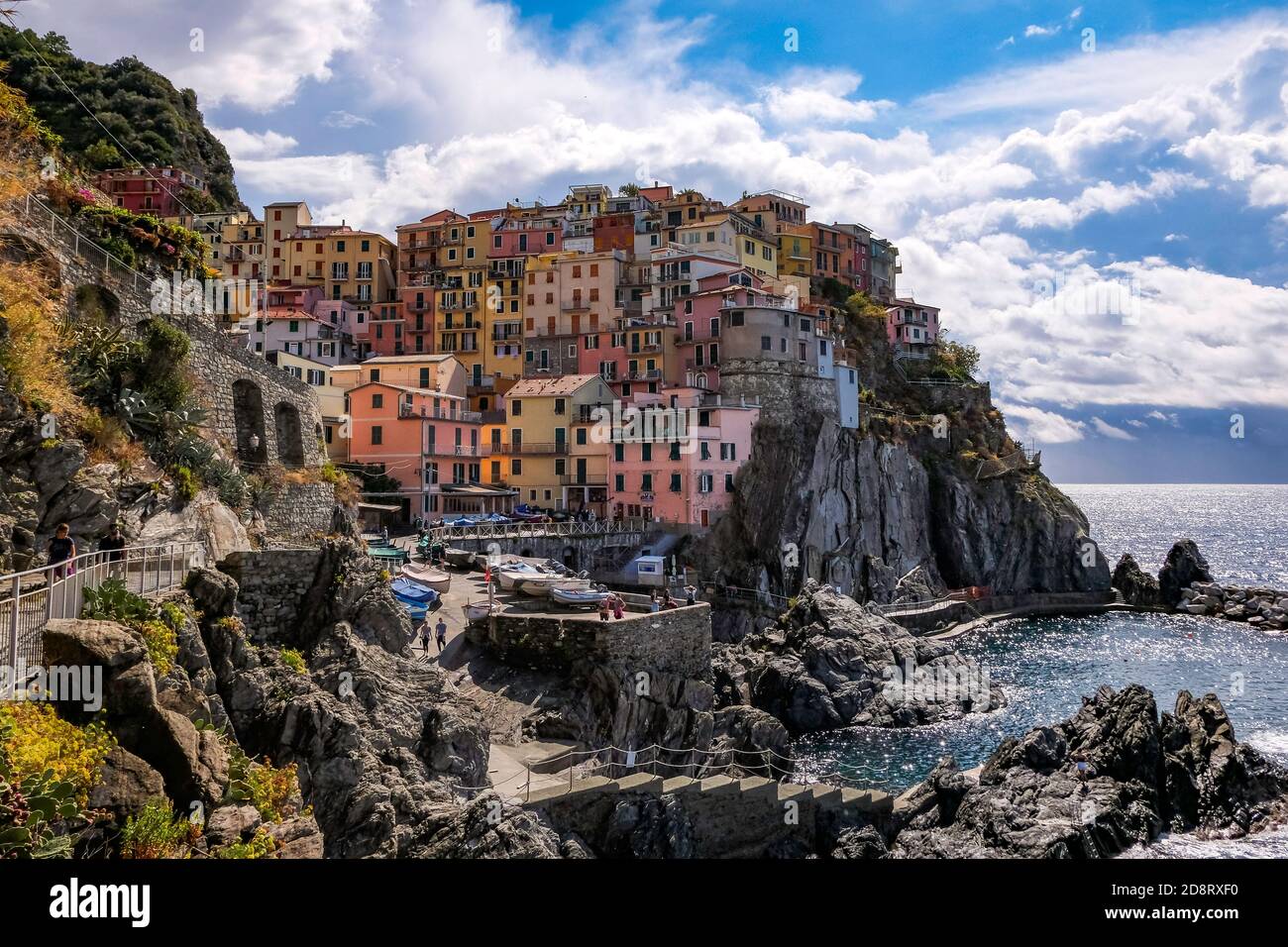 Vista clásica de Manarola, Cinque Terre, Italia - Colorful Houses en una formación de roca de acantilado espectacular cerca del mar con un puerto natural de pesca Foto de stock