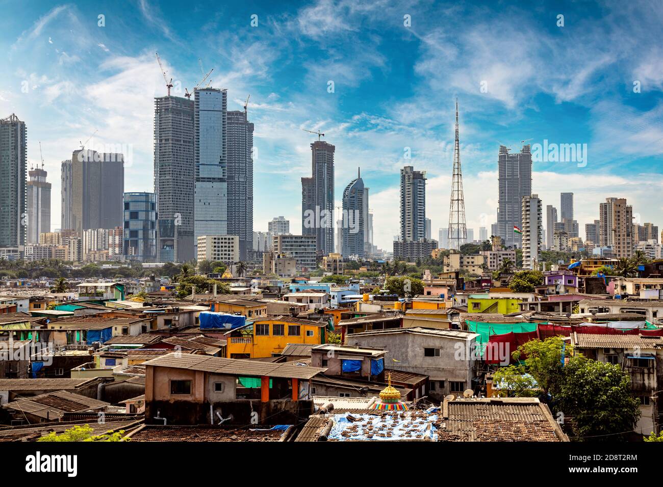 Vistas de los barrios de tugurios en las orillas de mumbai, India, con el telón de fondo de rascacielos en construcción Foto de stock