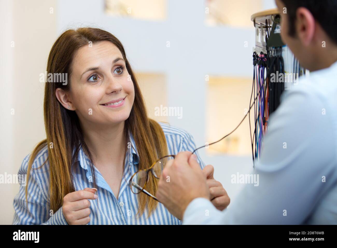 mujer joven recibiendo una consulta de un óptico Foto de stock