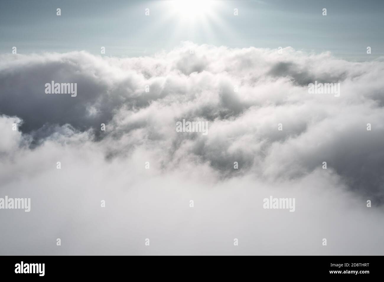 Nubes en el cielo con el sol brillando. Fotografía aérea de aventura al aire libre, vista mientras parapente por encima de las nubes. Foto de stock