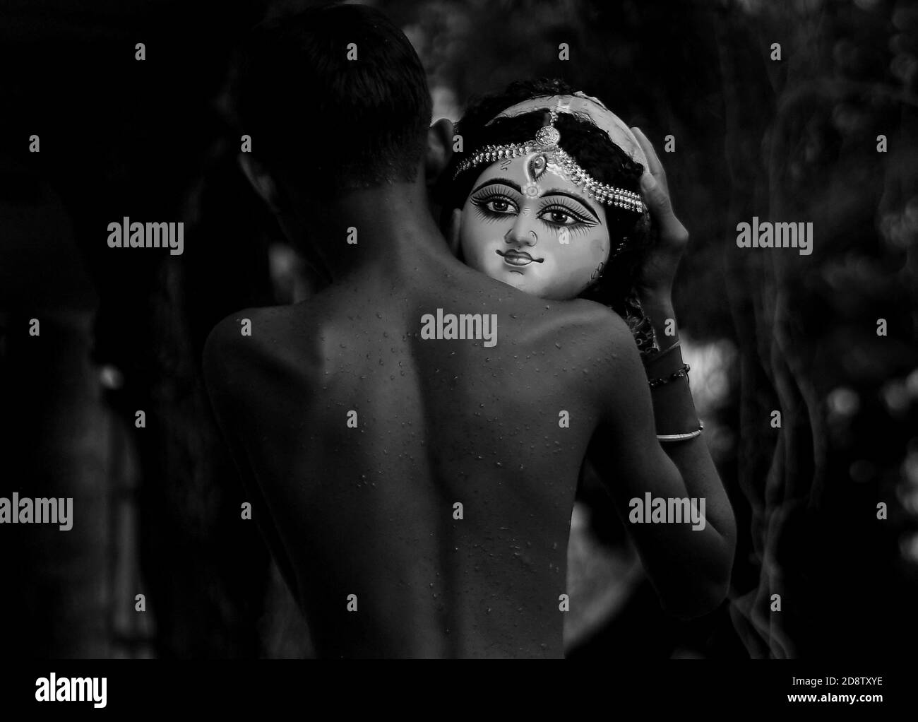 Un niño sostiene la cabeza de un ídolo de la diosa Durga durante una ceremonia de inmersión para Dashami, el último día del festival Durga Puja. El festival es el mayor evento religioso para los hindúes bengalíes. Los hindúes creen que la diosa Durga simboliza el poder y el triunfo del bien sobre el mal. Agartala, Tripura, India. Foto de stock