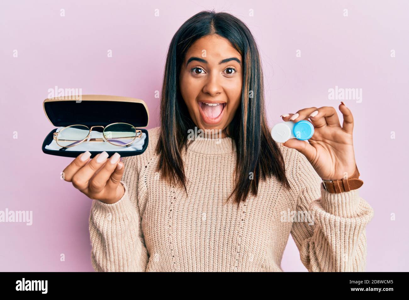 Joven latina sosteniendo gafas y lentes de contacto celebrando loco y  sorprendido por el éxito con ojos abiertos gritando emocionado Fotografía  de stock - Alamy