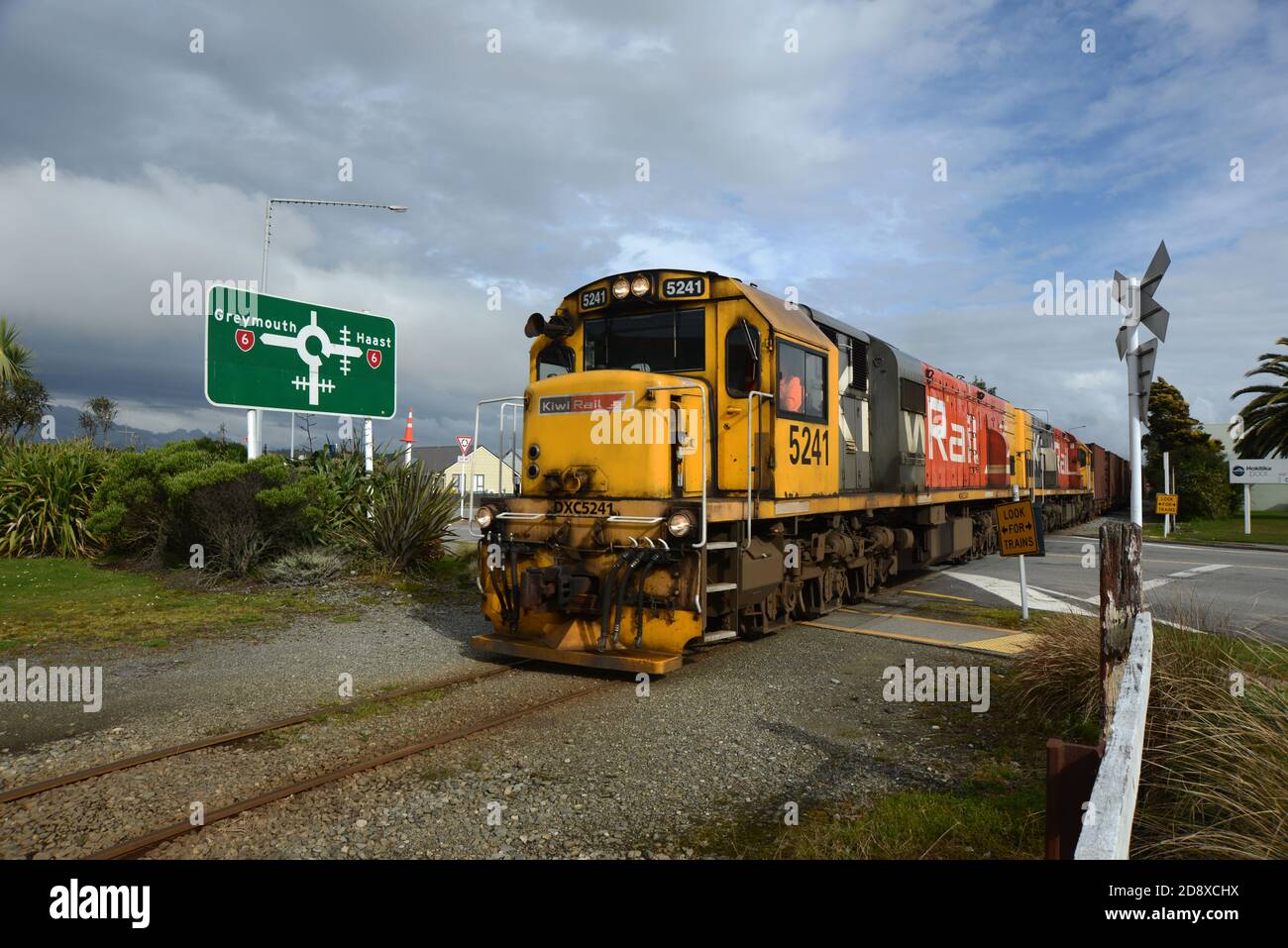 HOKITIKA, NUEVA ZELANDA, 29 DE AGOSTO de 2020: Un tren de carga cruza la calle principal de Hokitika cerca de la rotonda de la autopista estatal 6. Foto de stock