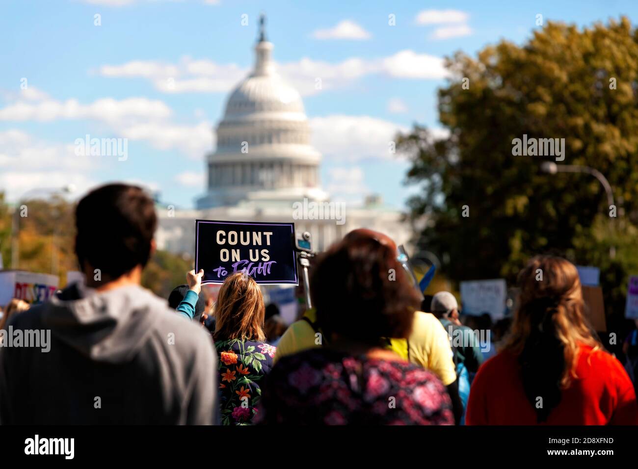 Una mujer lleva una señal que dice "cuente con nosotros", hacia el Capitolio de los EE.UU. Durante la marcha de las mujeres el 17 de octubre de 2020, Washington, DC, EE.UU Foto de stock