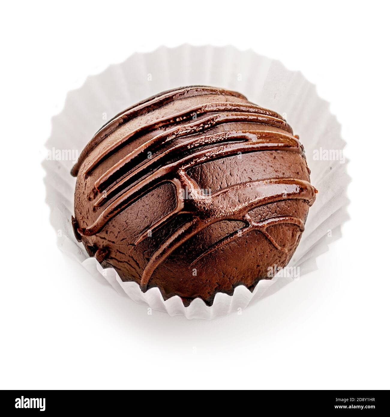 Chocolate redondo caramelo cubierto con franjas de chocolate aisladas sobre fondo blanco, macro Foto de stock