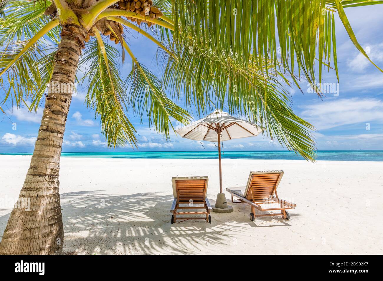 Hermosas sillas de playa con sombrilla en la playa tropical de arena blanca