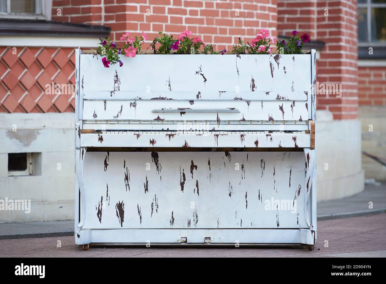 Viejo piano blanco con flores para la decoración del jardín Foto de stock