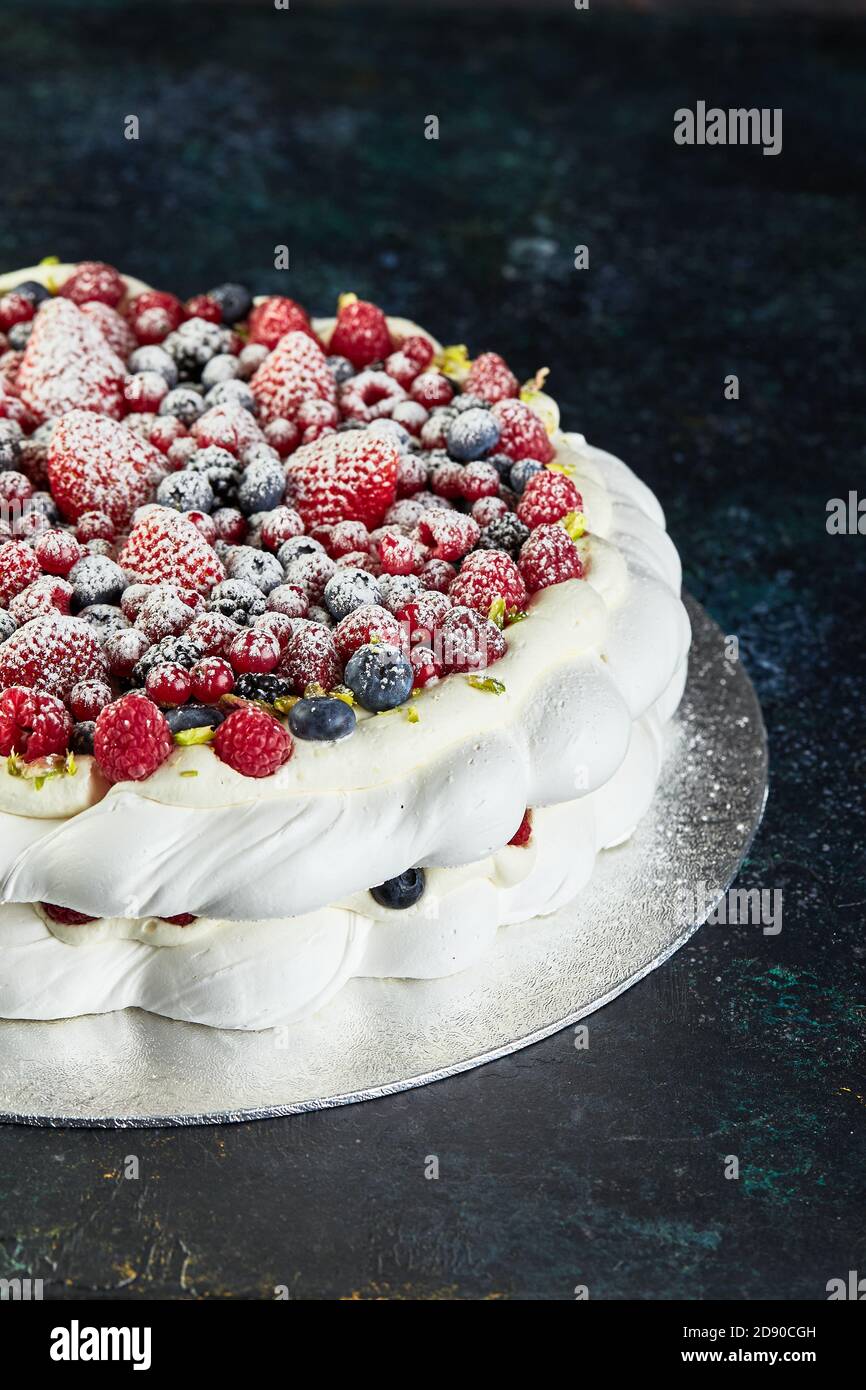 Merengue pavlova guirnalda tortas con nata montada y bayas frescas, de cerca Foto de stock