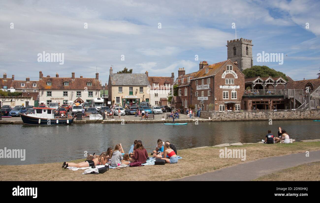 Los adolescentes se sentaron junto al río Frome en Wareham, Dorset en el Reino Unido, tomado el 23 de julio de 2020 Foto de stock