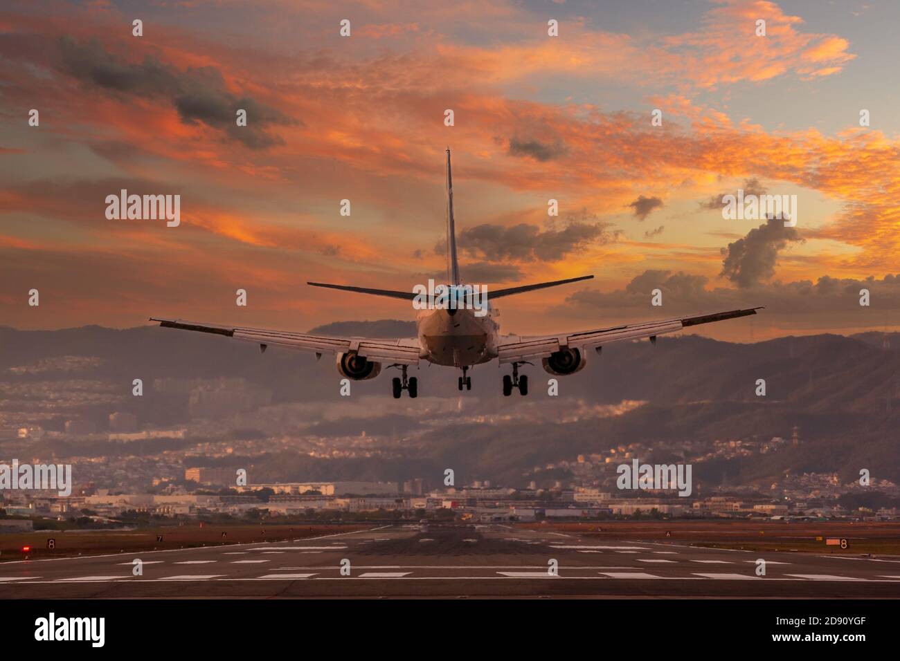 gran avión aterrizando durante la puesta de sol Foto de stock