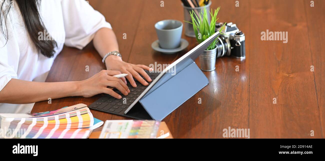 Primer plano de las manos de diseño gráfico retoque imágenes utilizando gráficos de dibujo tableta en un programa especial y paleta de colores en el estudio de fotos. Foto de stock