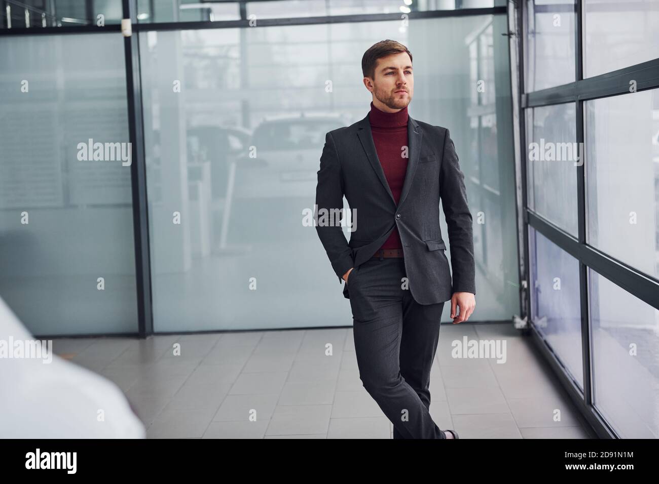 Joven hombre de negocios en traje de lujo y ropa formal es en el interior  de la oficina Fotografía de stock - Alamy