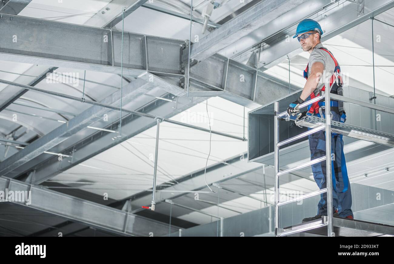 HVAC Technologies almacén instalador de circulación de aire en descafeinado de aluminio preparación para realizar ajustes finales de las salidas de aire. Foto de stock