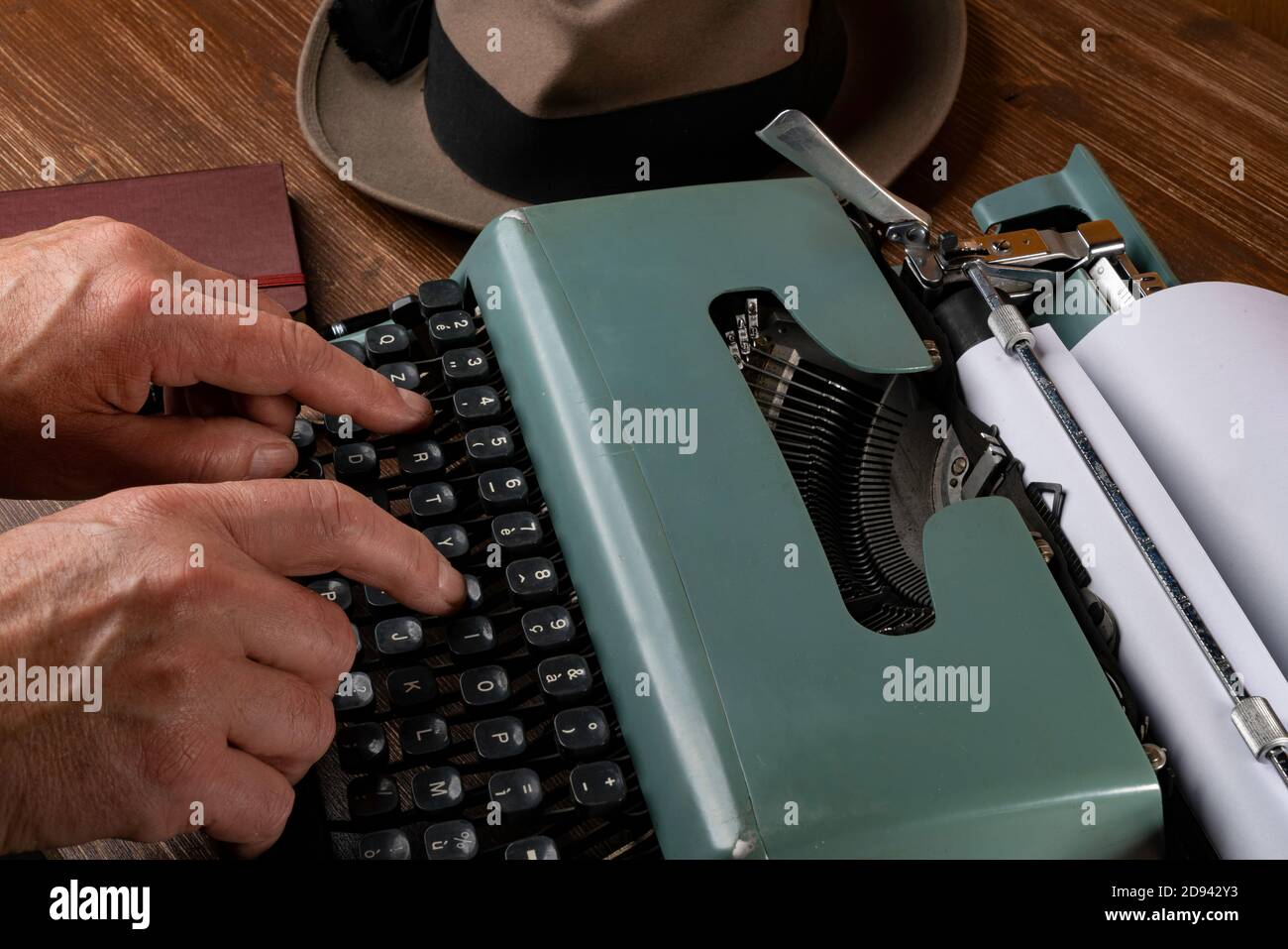 un hombre mientras escribe con una máquina de escribir vieja Foto de stock