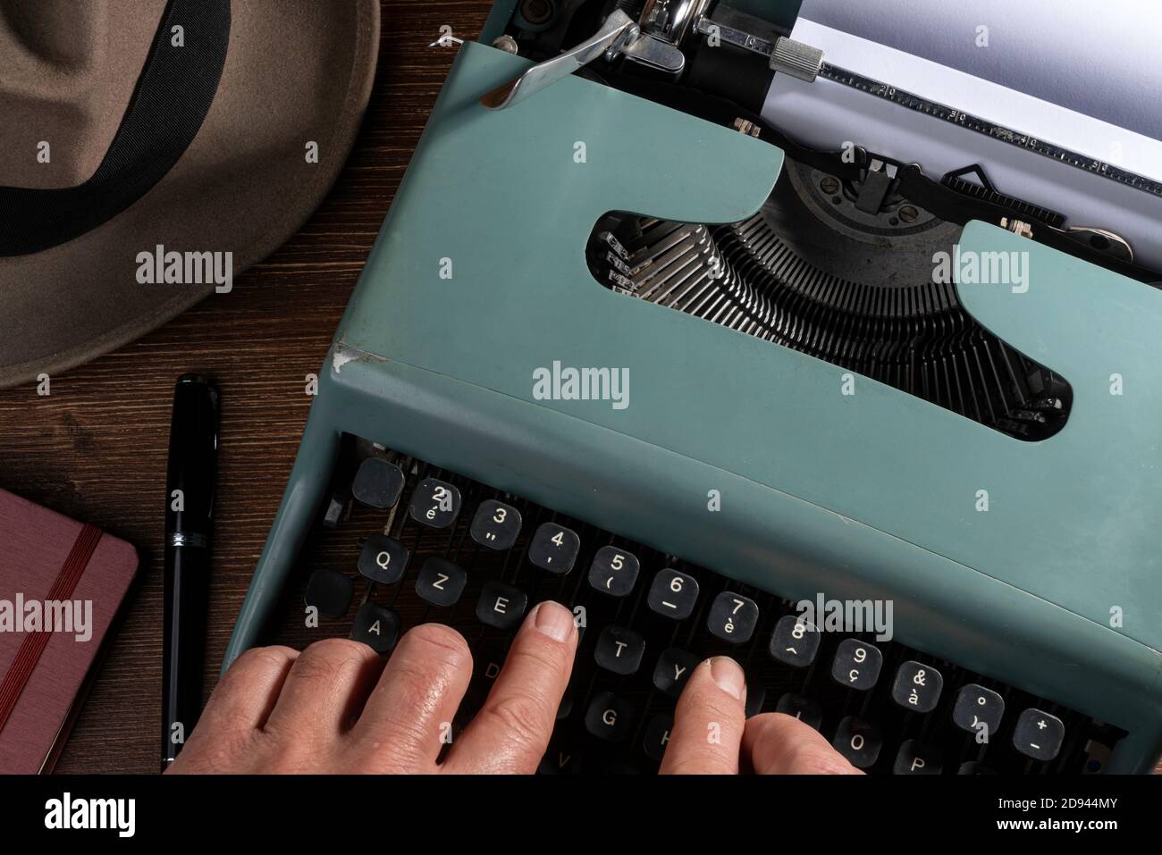 un hombre mientras escribe con una máquina de escribir vieja Foto de stock