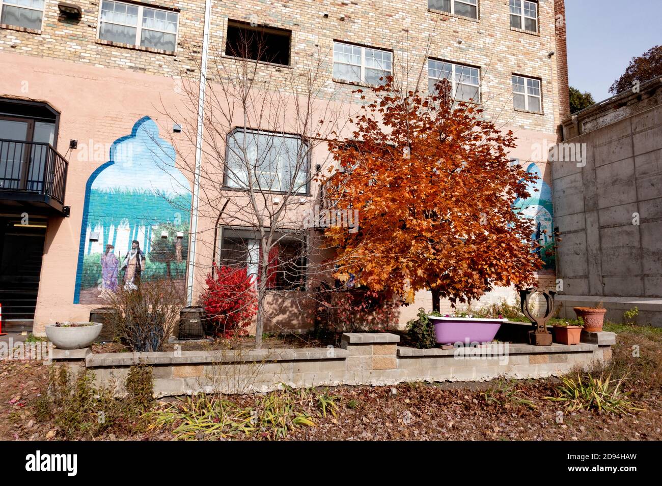 Edificio de apartamentos Mideast con un patio decorado y un hermoso árbol de otoño situado junto al sendero Midtown Greenway. Minneapolis Minnesota MN EE.UU Foto de stock