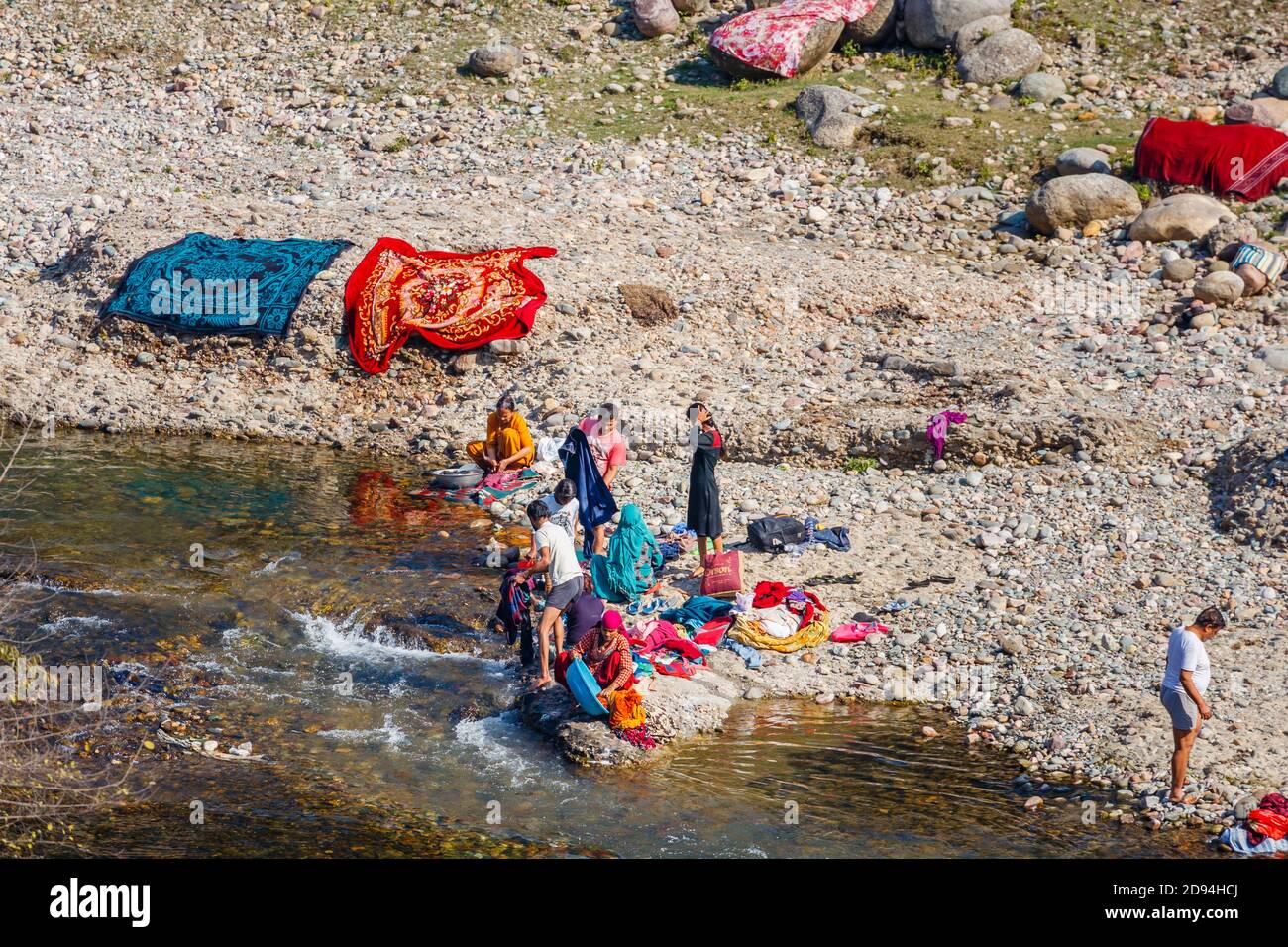 La gente local lavaba y secaba la ropa al sol en el lado de un río en Kaswara, cerca de Old Kangra y el fuerte de Kangra en Himachal Pradesh, al norte de la India Foto de stock