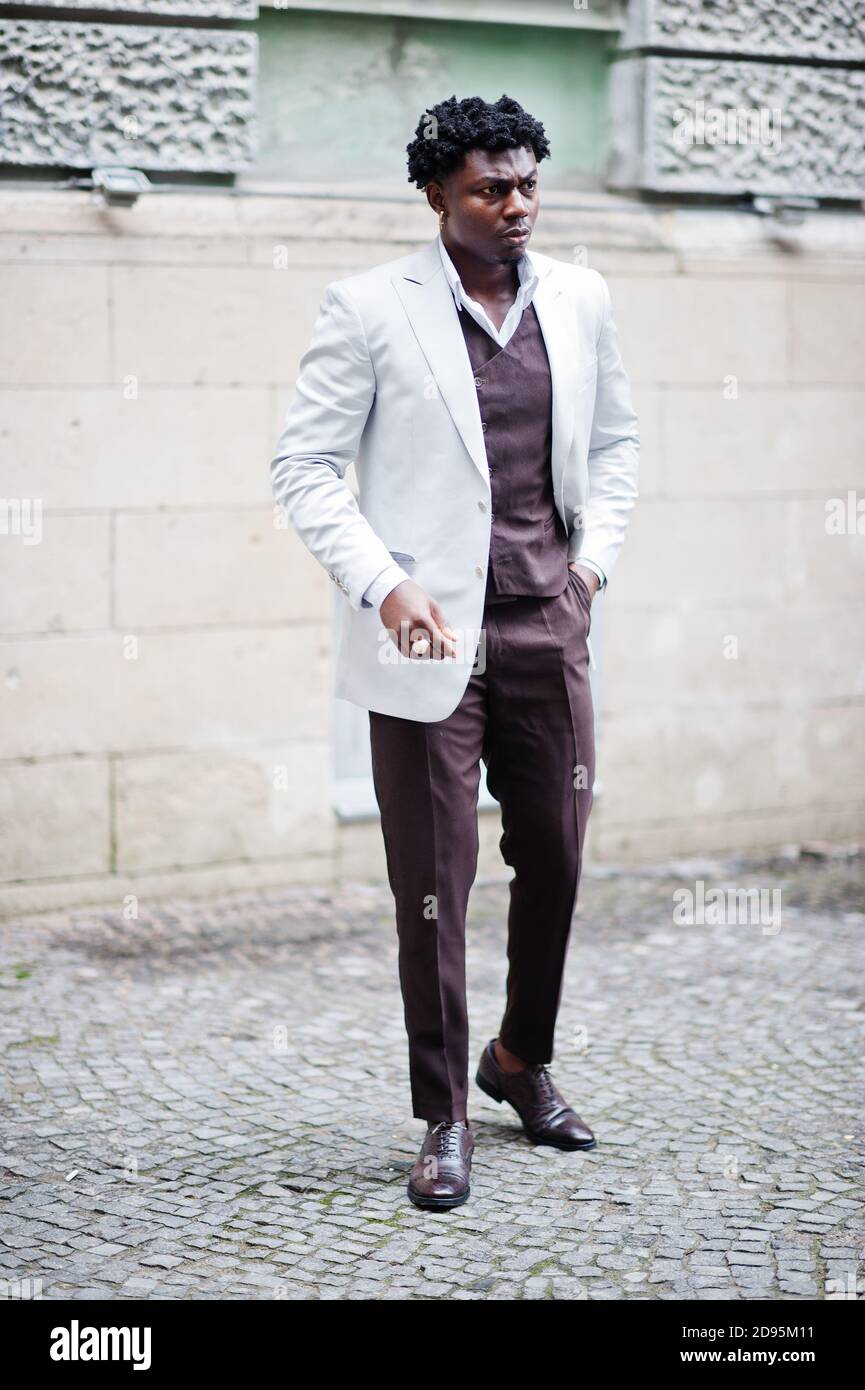 Pensativo joven guapo caballero afroamericano en ropa formalwear. Modelo negro elegante hombre en chaqueta blanca Fotografía de stock - Alamy