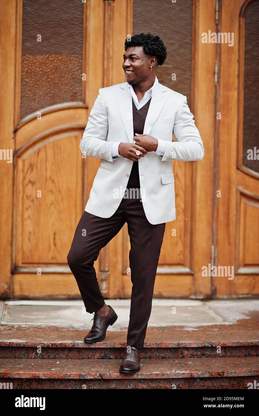 Pensativo joven guapo caballero afroamericano en ropa de formalwear. Modelo  negro elegante hombre en chaqueta blanca Fotografía de stock - Alamy
