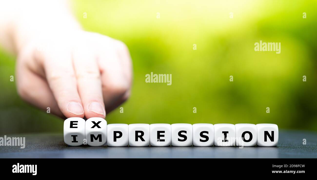 La mano se convierte en dados y cambia la palabra "impresión" por "expresión". Foto de stock
