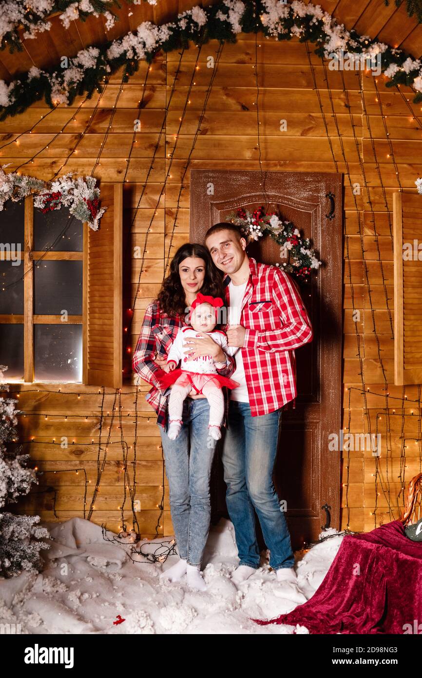Mama Y Papa Posan Con Su Encantadora Hija En Un Estudio De Navidad Decorado Sesion Fotografica De Ano Nuevo Fotografia De Stock Alamy