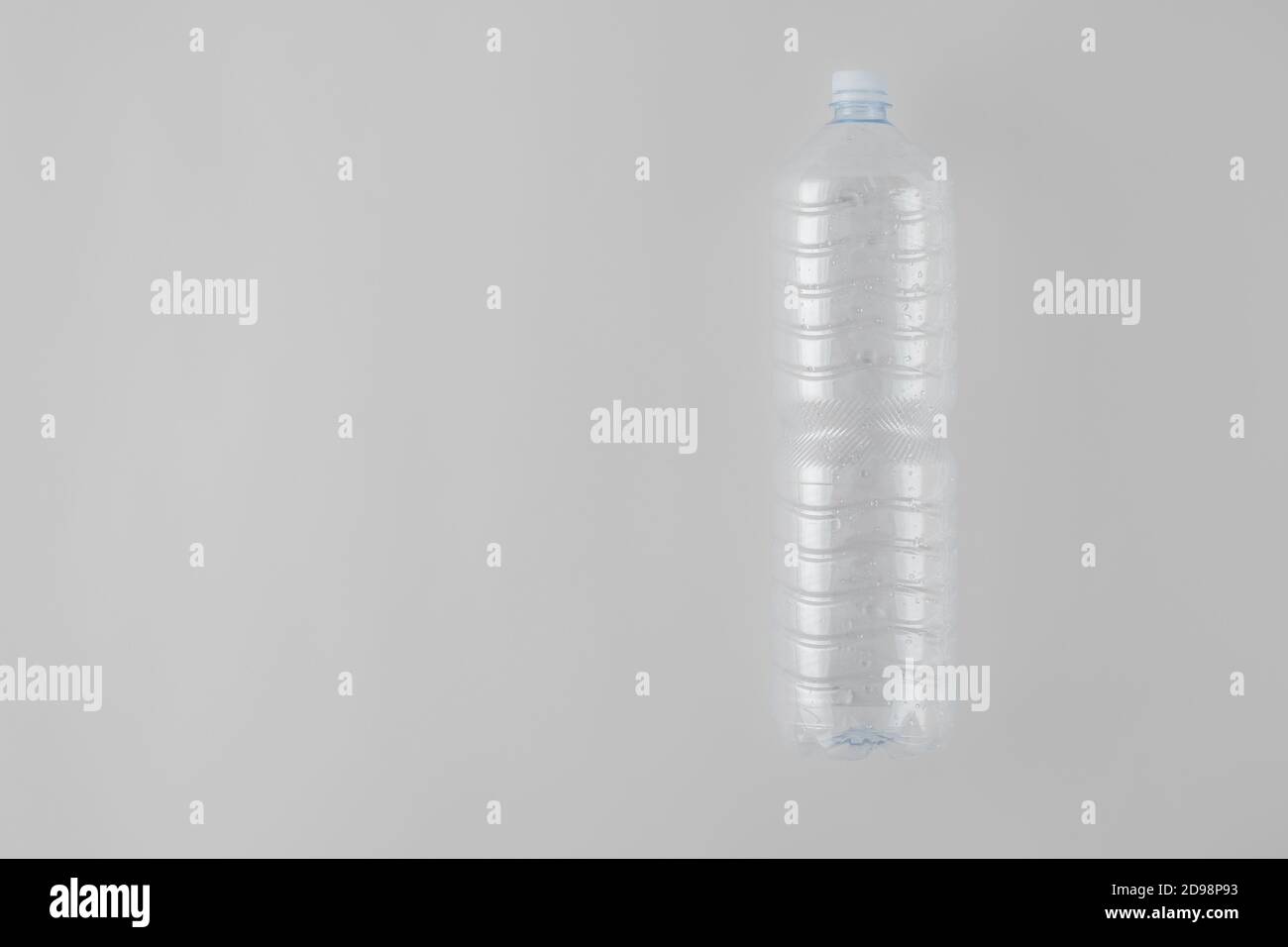 Botella de agua de plástico vacía sobre fondo gris Foto de stock