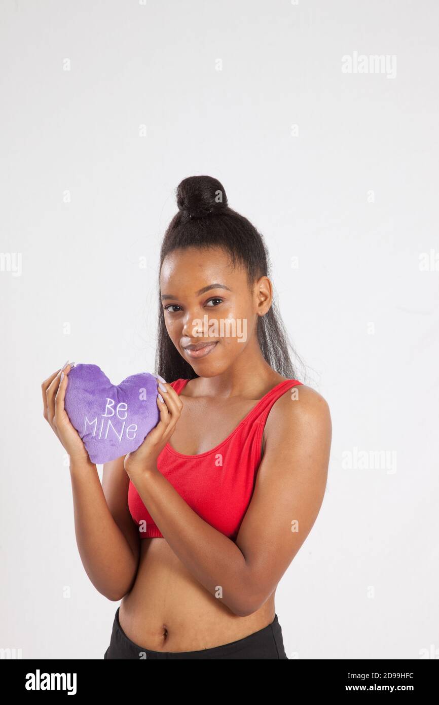 Mujer negra encantadora sosteniendo un corazón púrpura Foto de stock