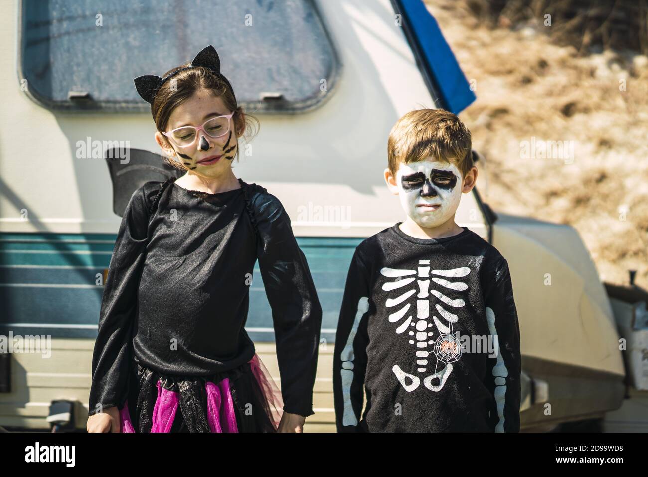 Hermana y hermano usando disfraces de Halloween y de pie contra un camper  Fotografía de stock - Alamy