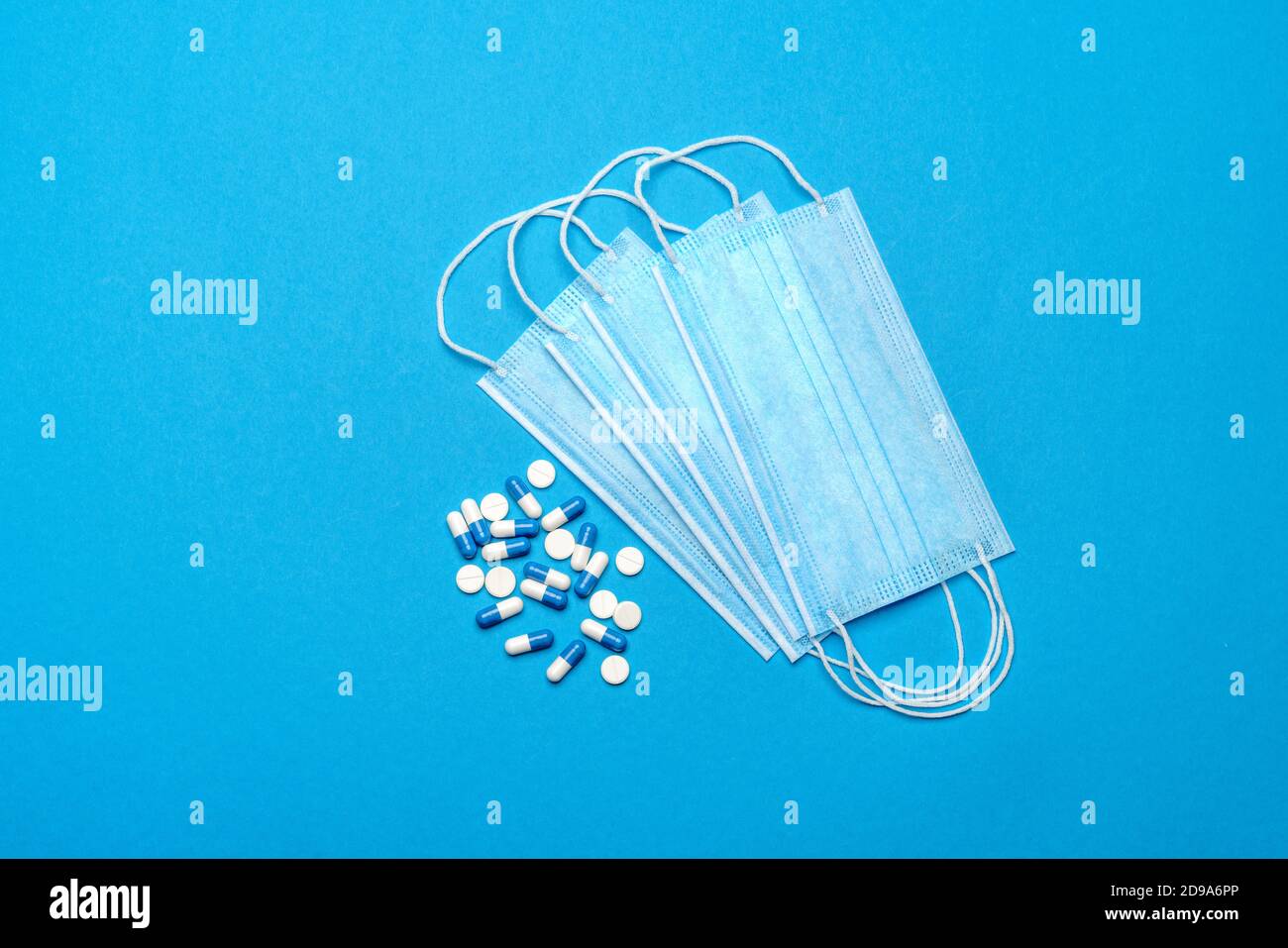 Mascarillas y pastillas médicas protectoras sobre un fondo azul - Vista  superior con espacio de copia Fotografía de stock - Alamy