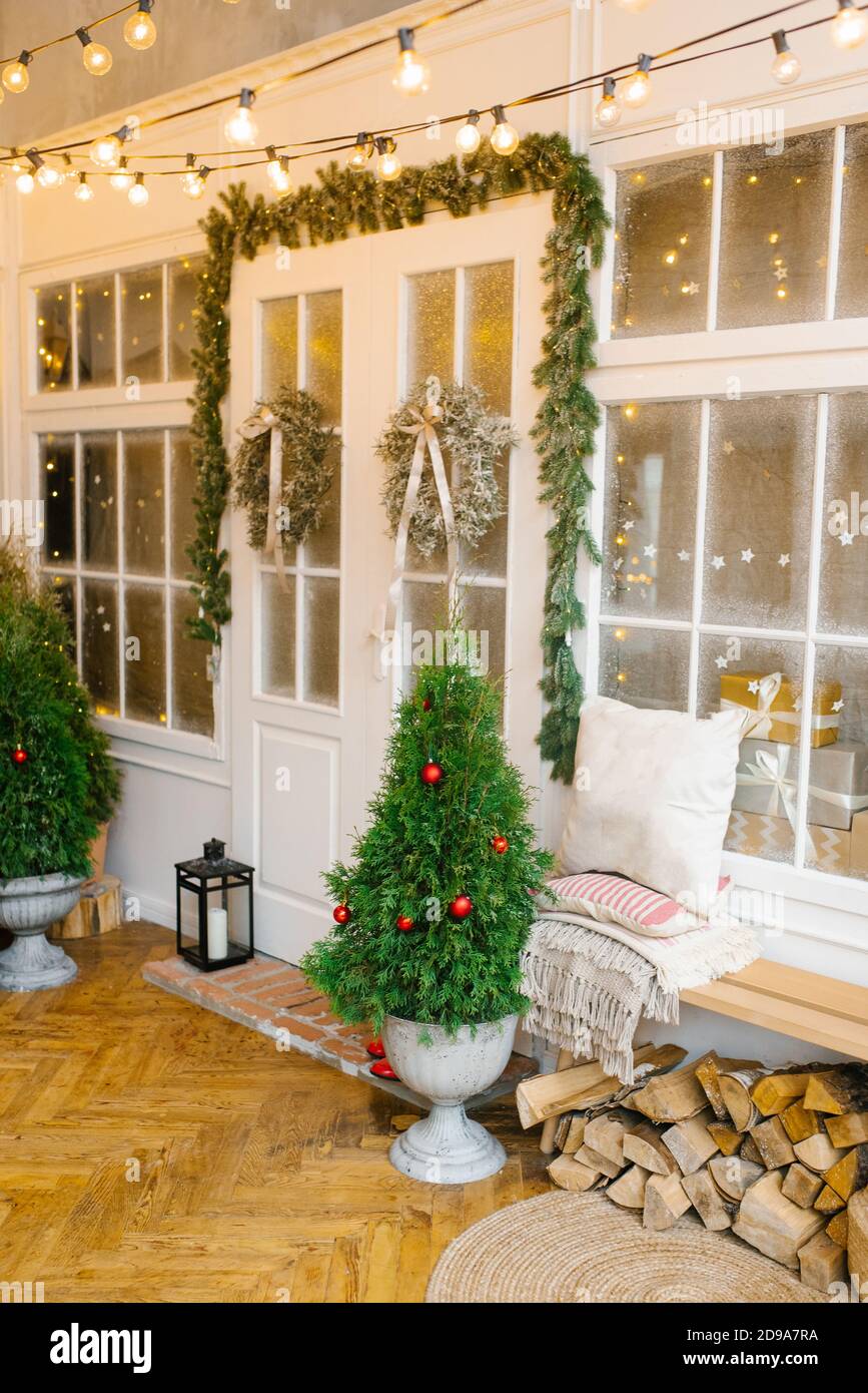 Puertas de entrada a la casa, decoradas para Navidad y año Nuevo. Árboles en  jarrones y coronas de Navidad en puertas blancas Fotografía de stock - Alamy