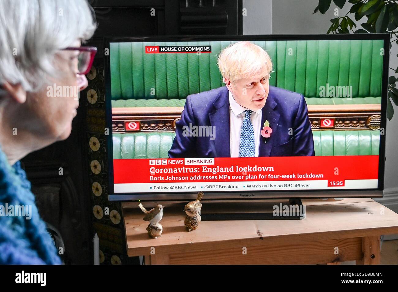 Un espectador viendo un anuncio televisado de Boris Johnson del Parlamento sobre el "segundo cierre de Inglaterra", con el texto "bloqueo de Inglaterra". Foto de stock