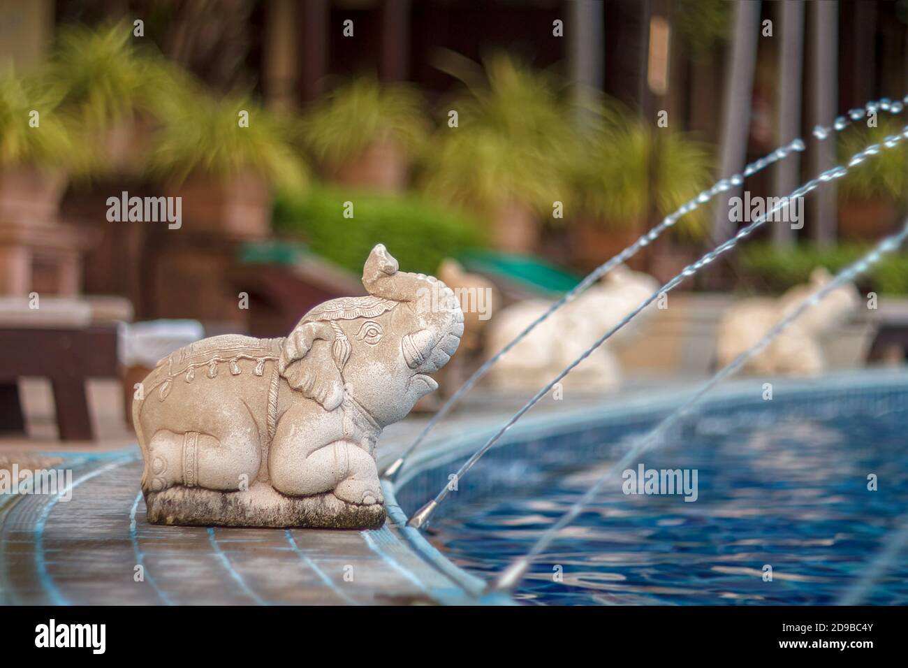 Piscina de lujo al aire libre y agua de elefante. Las estatuas de elefantes rocían agua de una piscina. Hormigón elefante. Estatua de elefante junto a la piscina. Foto de stock