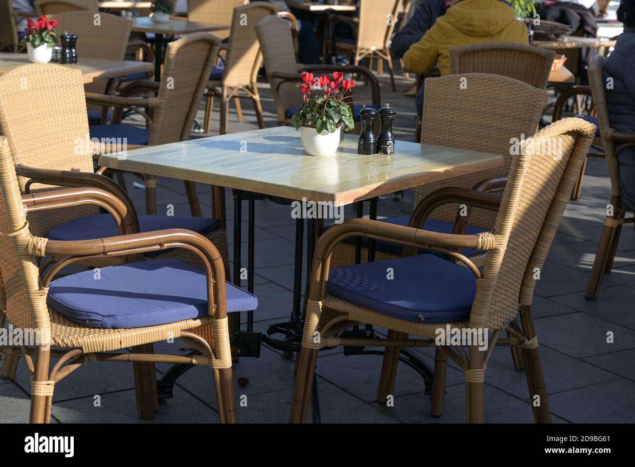 Mesa vacía en un café callejero en un día soleado después de la estricta encierro durante la pandemia de coronavirus, enfoque seleccionado Foto de stock