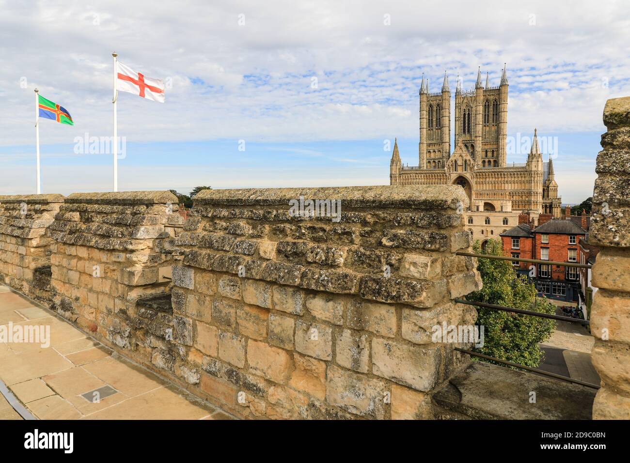Banderas volando sobre la pasarela en las murallas del Castillo de Lincoln con la Catedral de Lincoln en el fondo, la ciudad de Lincoln, Lincolnshire, Inglaterra, Reino Unido Foto de stock