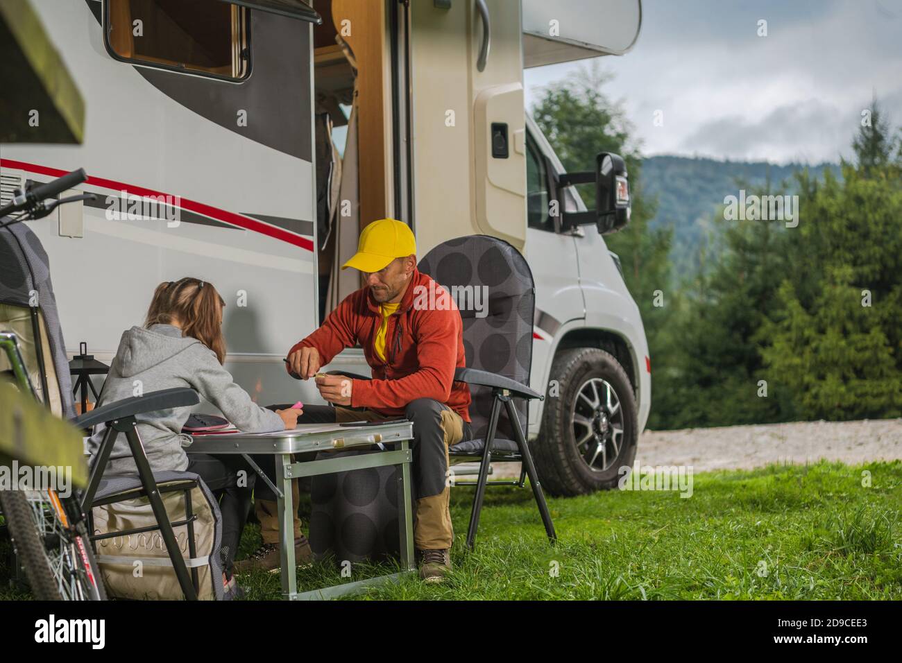 Padre caucásico con su hija Colgante junto al moderno Camper Van clase C Autocaravana. Familia RV Parque Camping tema. Foto de stock