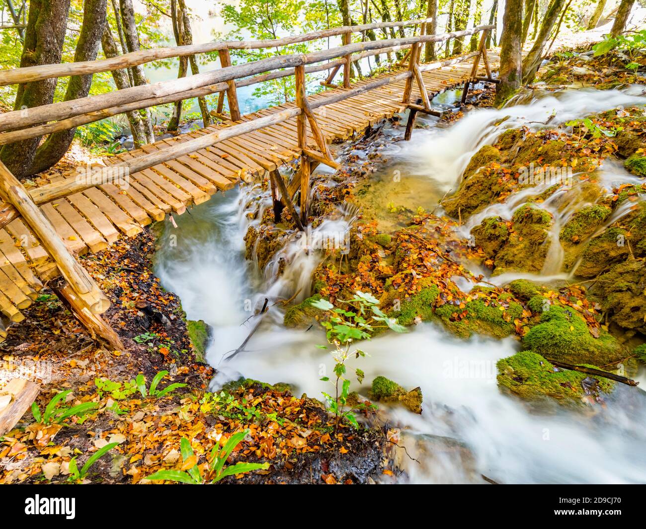Fantásticas vistas de las pequeñas cascadas bajo el puente peatonal en el Parque Nacional Lagos de Plitvice, Croacia Foto de stock