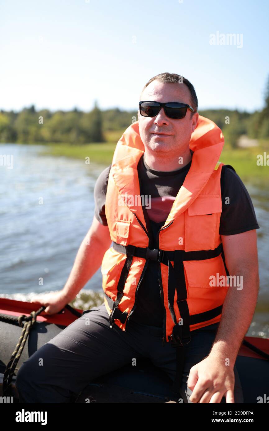 Hombre en chaleco salvavidas en barco en los skerries de Ladoga Fotografía  de stock - Alamy