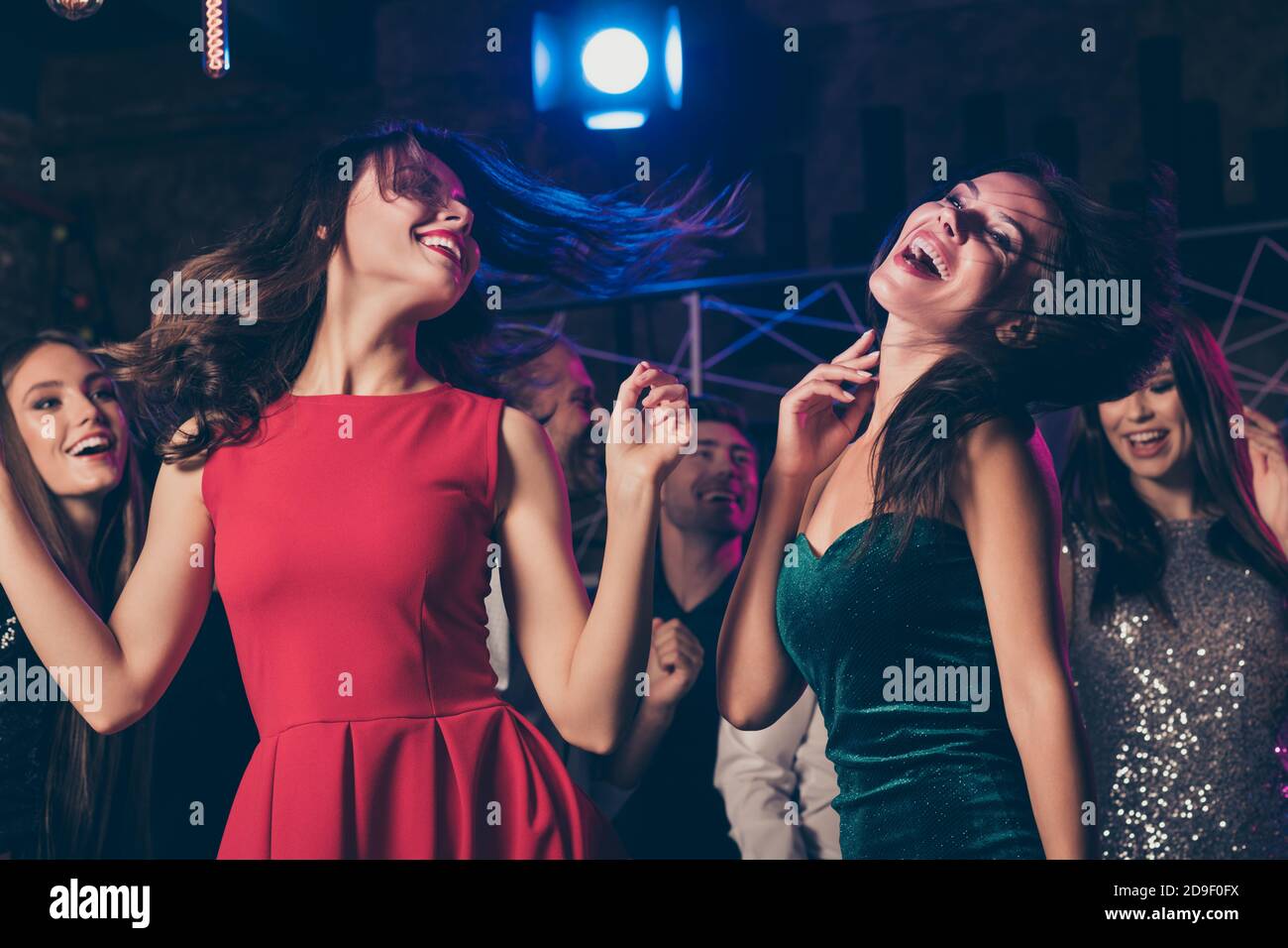 Foto de la fiesta corporativa de la gente bonita alegre que viste festivo ropa bailando juntos Foto de la fiesta corporativa de la gente bonita alegre que viste festivo ropa bailando juntos