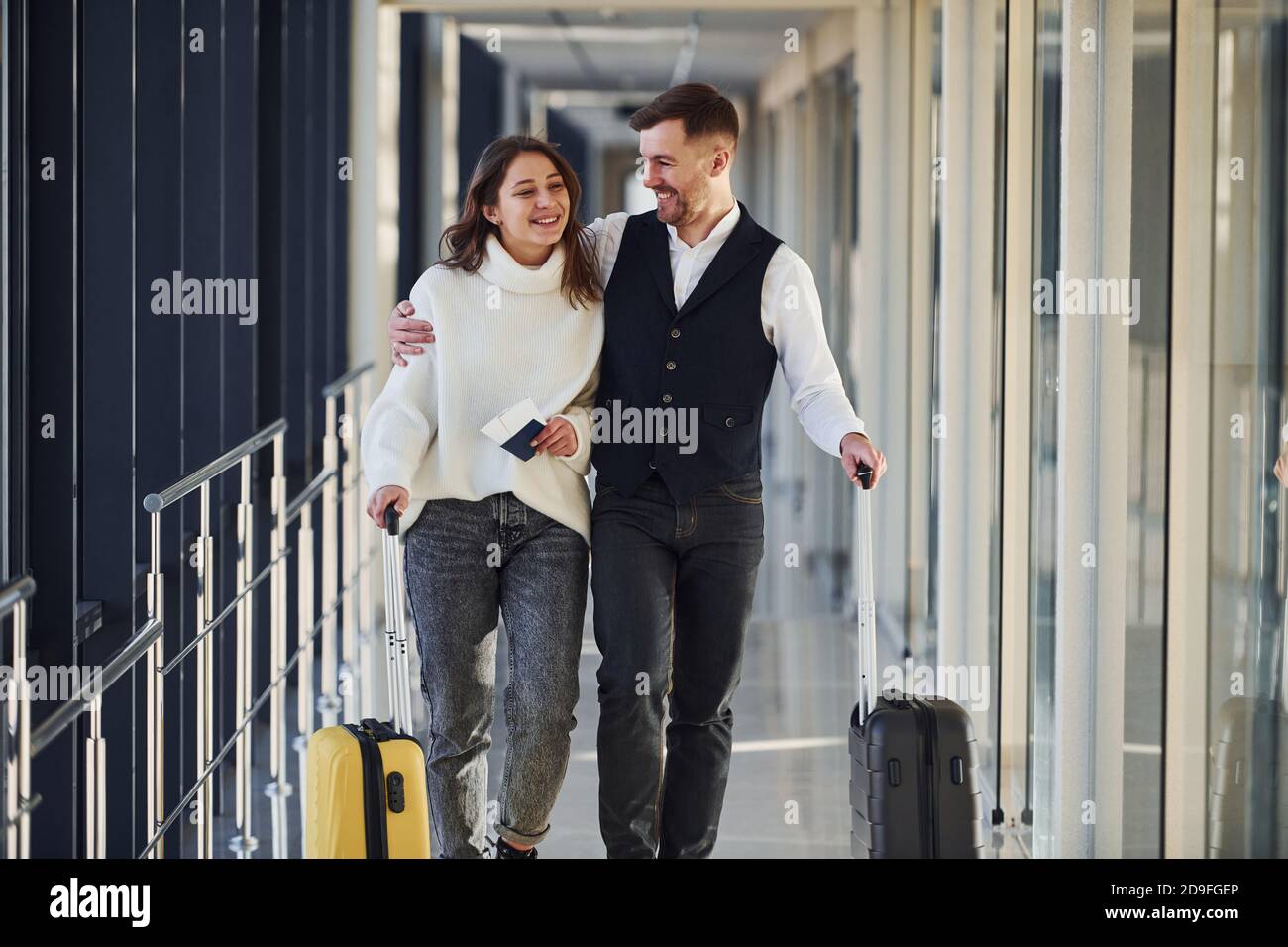 Hombre con ropa elegante formal caminando con una joven en el interior en  el aeropuerto Fotografía de stock - Alamy