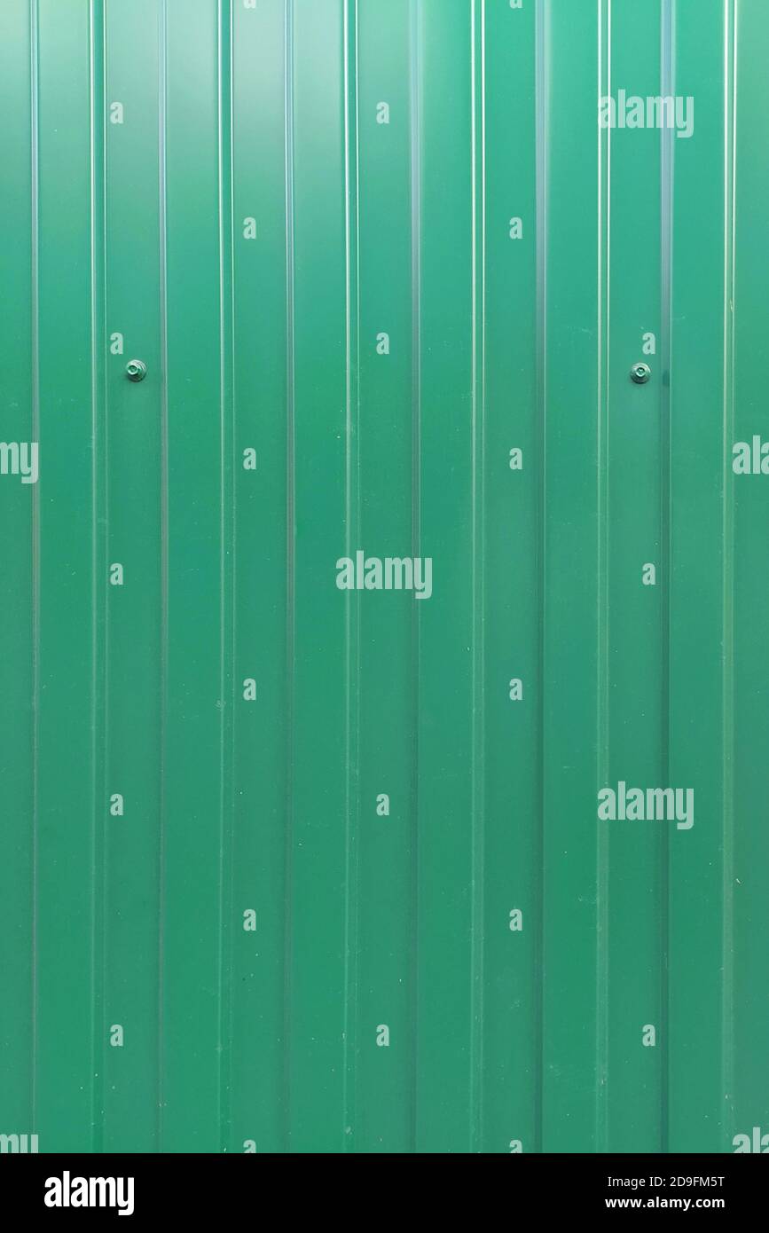 La valla verde de la plancha de hierro corrugado se fija a los pernos.  Fondo para texto y diseño Fotografía de stock - Alamy